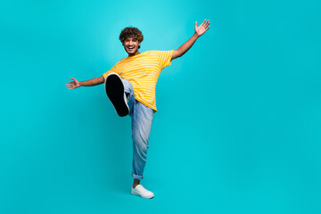 Fototapeta na wymiar Full size photo of handsome cheerful person dancing raise shoe empty space isolated on teal color background