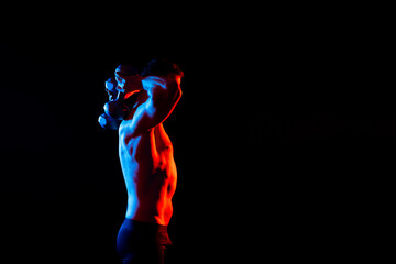 Handsome young fitness sporty strong guy bare-chested muscular sportsman on studio background