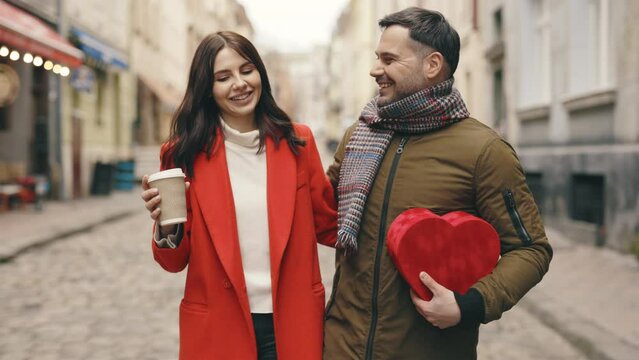Happy couple in love. Caucasian family walking around the city, talking, spending time together, drinking coffee. Romance, relationships. Valentine's day. Festive mood.