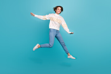 Fototapeta na wymiar Full body size cadre of jumper crazy woman lightness freedom wear trendy pullover jeans have fun isolated on blue color background