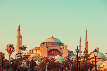 Fototapeta premium Hagia sophia sunset minarets palm trees Istanbul Turkey ottoman mosque iconic landmark view ancient structure famous historic site cultural monument