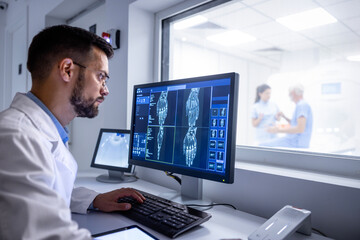 MRI diagnostic center control room and neurologist examining patient X-ray images on large display.