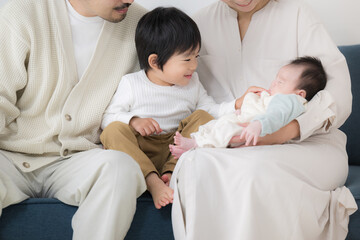 Big brother touching his newborn brother Happy family