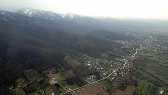 Aerial view of a town Leskovac nestled at the foothill of the mountain in southern Serbia while snow falls