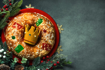 Top view of Roscon de reyes with cream and crown of the three wise men on a red plate with space for text. Kings day concept spanish three kings cake - obrazy, fototapety, plakaty