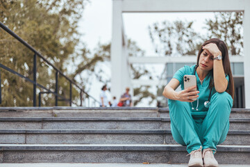 Shot of a female nurse suffering from a serious headache while working inside a hospital. Emotional stress of young doctor. Exhausted tired doctor or nurse. Virus outbreak