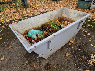 
tin container for storing biowaste from a gardening company branches of leaves and cut grass open...