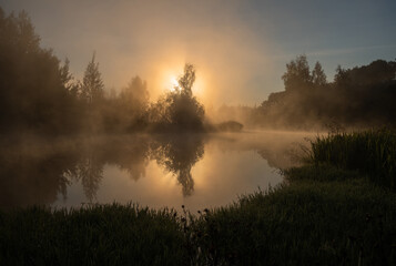 Dawn over a foggy river