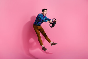 Fototapeta na wymiar Full length photo of funky young driver jumping holding steering wheel high speed transportation isolated on pink color background