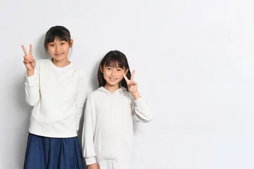 Fotobehang ピースをする笑顔の女子小学生達  © koumaru