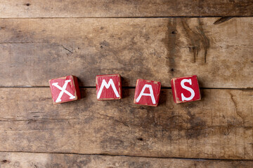 Christmas background with an inscription X-mas on old wooden board