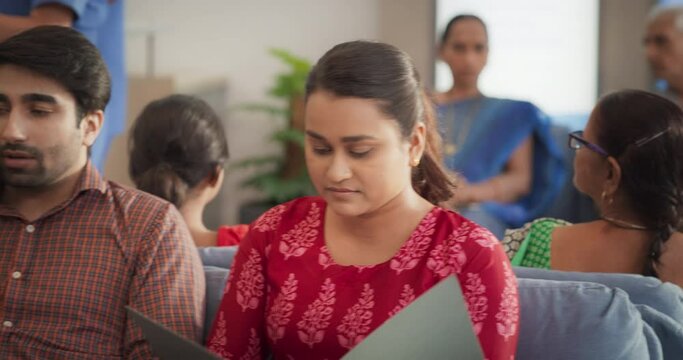 Dolly Shot Showing Portraits of Patients Waiting in Reception Hall in a Hospital. Indian Diverse Group Talking, Checking Medical Analysis Report in a Busy Local Health Clinic During the Day