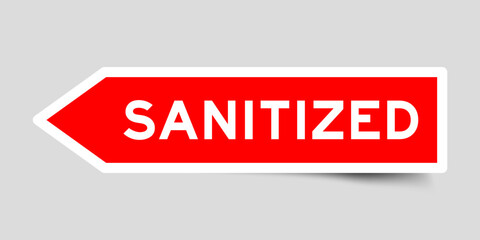 Red color arrow shape sticker label with word sanitized on gray background