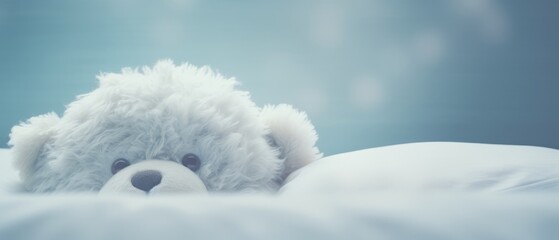 A teddy bear is sitting on a cozy bed
