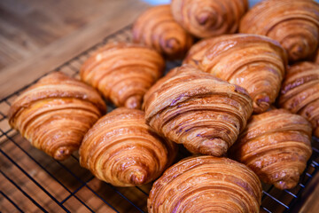 Homemade croissant on stainless steel grill and on  wood background, bakery