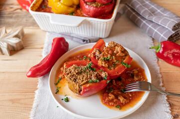 Stuffed pepper with minced meat filling and tomato sauce cut in half on a plate