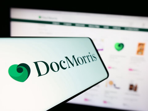 Stuttgart, Germany - 11-08-2023: Smartphone with logo of Swiss online pharmacy company DocMorris AG in front of business website. Focus on center-left of phone display.