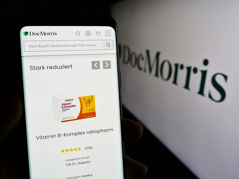 Stuttgart, Germany - 11-08-2023: Person holding smartphone with web page of Swiss online pharmacy company DocMorris AG in front of logo. Focus on center of phone display.