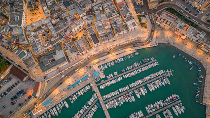 Fototapeta premium Aerial view of seafront and old town Bisceglie in Puglia with drone on sunset.