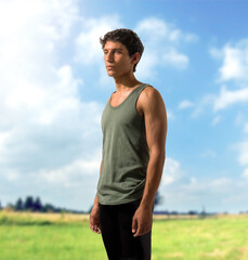 A man in a tank top standing in a field