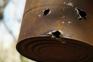 Closeup of a damaged rustic metallic bucket in a park - obrazy, fototapety, plakaty