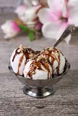 Summer cold dessert - three balls plombir ice cream   with chocolate sauce, crushed peanut nuts 