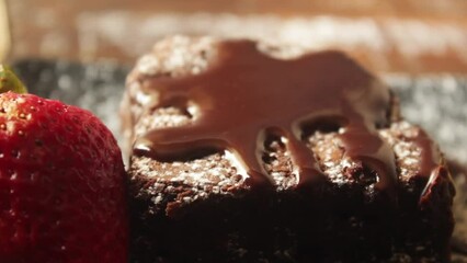 A small with ice cream and pitcher pours liquid chocolate over pieces of delicious brownies on a small tray. - Powered by Adobe