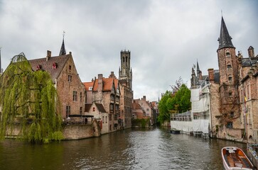 Fototapeta premium Beautiful view of the Rozenhoedkaai canal in Bruges with the belfry in the background