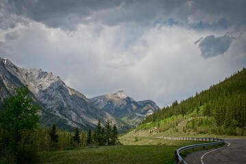 Beautiful view of a road to the majestic mountains under the stormy gray sky