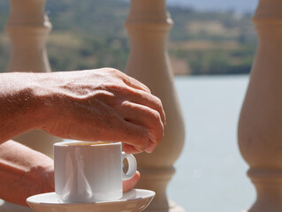 Manos de hombre con una taza de café con leche