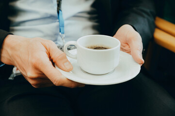 Image Foto Kongress - Close Up von Kaffee-Tasse in der Hand eines Kongressteilnehmers - obrazy, fototapety, plakaty