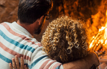Romantic couple enjoy flame in front of fireplace in winter at home - cozy romance love man and...