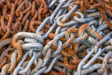 Close up of a pile of chain links corroding.