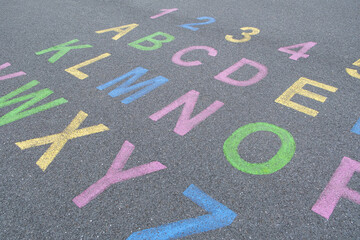 the alphabet and numbers are drawn with color paint on a children's playground designed creative display of the alphabet educational element learning space.