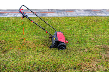 Scarifying the lawn before the winter season using an electric scarifier.