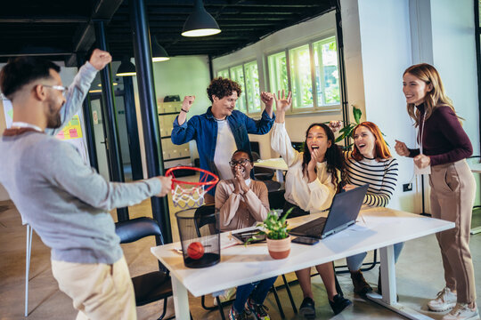 Young business people working together in the modern office have fun with basketball. Teamwork startup concept