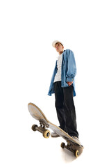 Bottom view image of teen boy in casual clothes standing with skateboard isolated over white...