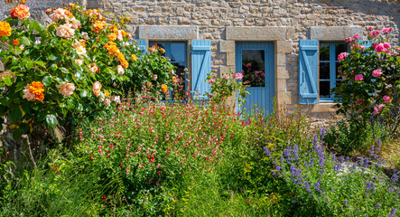 Fototapeta na wymiar Petit jardin fleuri au pied d'une charmante maison en Bretagne.
