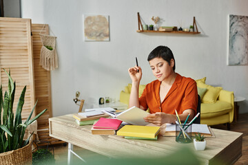 jolly young woman in casual homewear studying hard at desk and looking at book, education at home