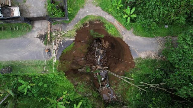 Ground under the road was eroded when the creek turned into a river due to heavy rains. The roadbed collapsed and a breach was created, an aerial view of the damage