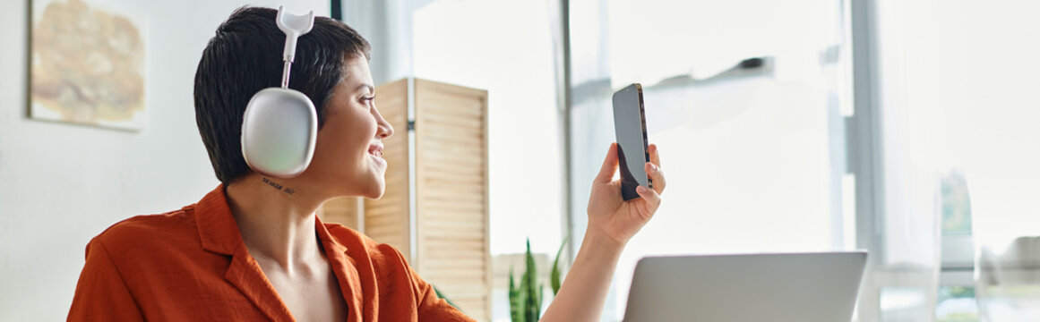 Jolly Pretty Woman In Orange Shirt With Headphones Taking Selfie In Front Of Laptop, Banner