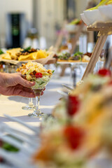 hands of a waiter prepare food for a buffet table in a restaurant