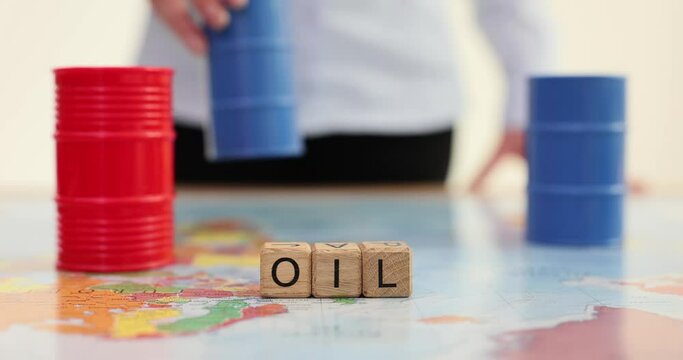 Woman puts barrel of oil on world map with word oil