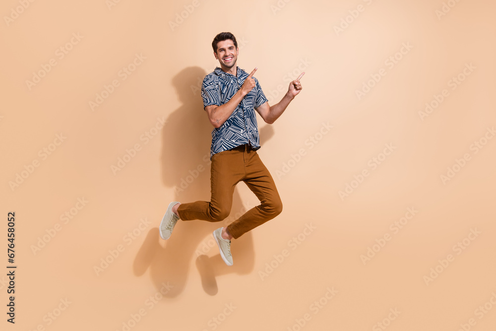 Poster full body size photo of crazy cheerful man jumping and directing two fingers mockup billboard ads is