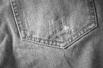 Texture of gray faded jeans with a pocket
