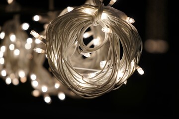 Closeup of a lit white fairy string lights in darkness