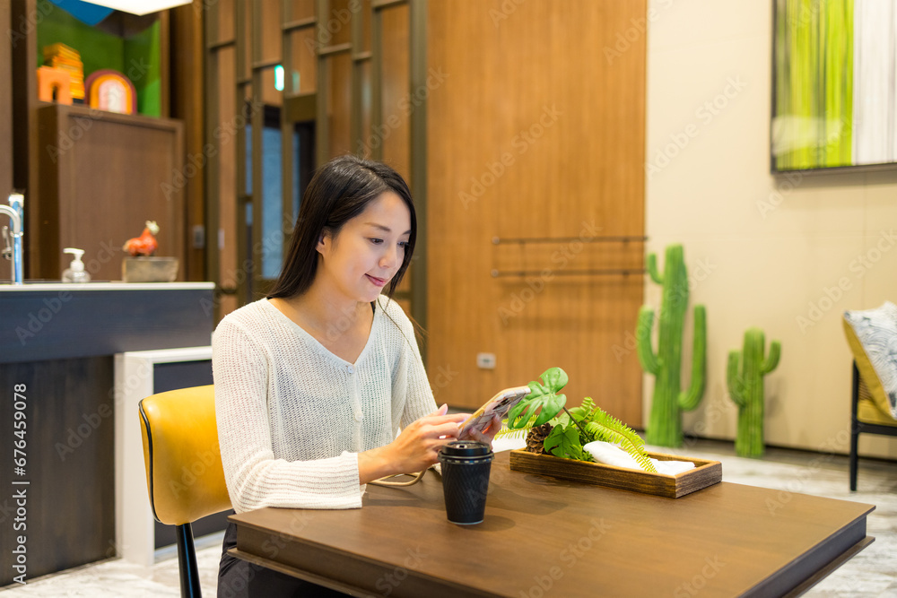 Wall mural Woman use of mobile phone in restaurant