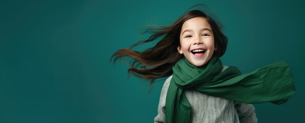 Happy Cute Girl Wearing a Green Scarf on a Green Background with Space for Copy