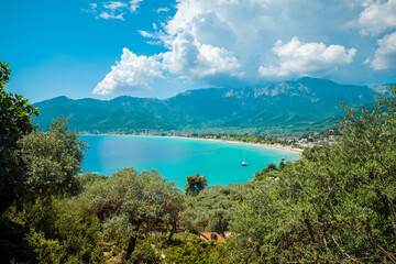 Stunning Coastal View of Bay with Turquoise Water, Olive Trees, Forested Hills, and Mountains under...