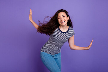 Photo of young carefree latin chic dancing alone when hearing her favorite hispanic soundtrack isolated on purple color background